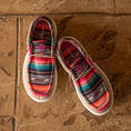Load image into Gallery viewer, A pair of Gator Waders Camp Shoes in a Serape pattern sitting on on a tile floor.