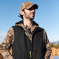 Load image into Gallery viewer, Man looking into the distance in a black Gator Waders Flyway Vest
